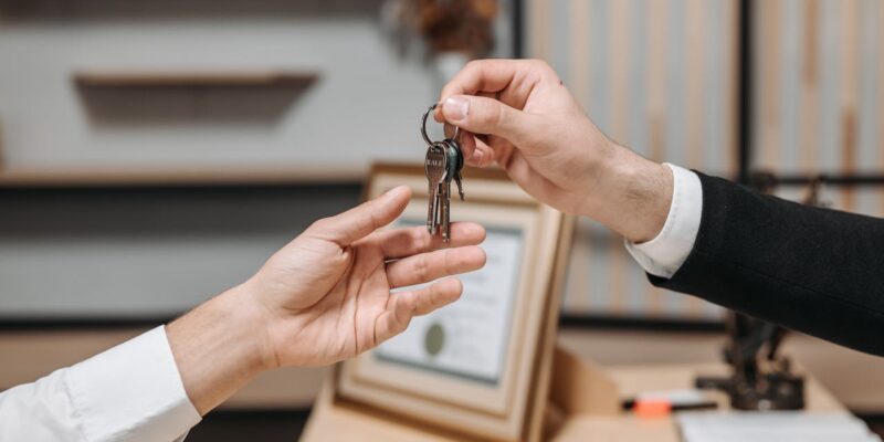 one person handing keys to another